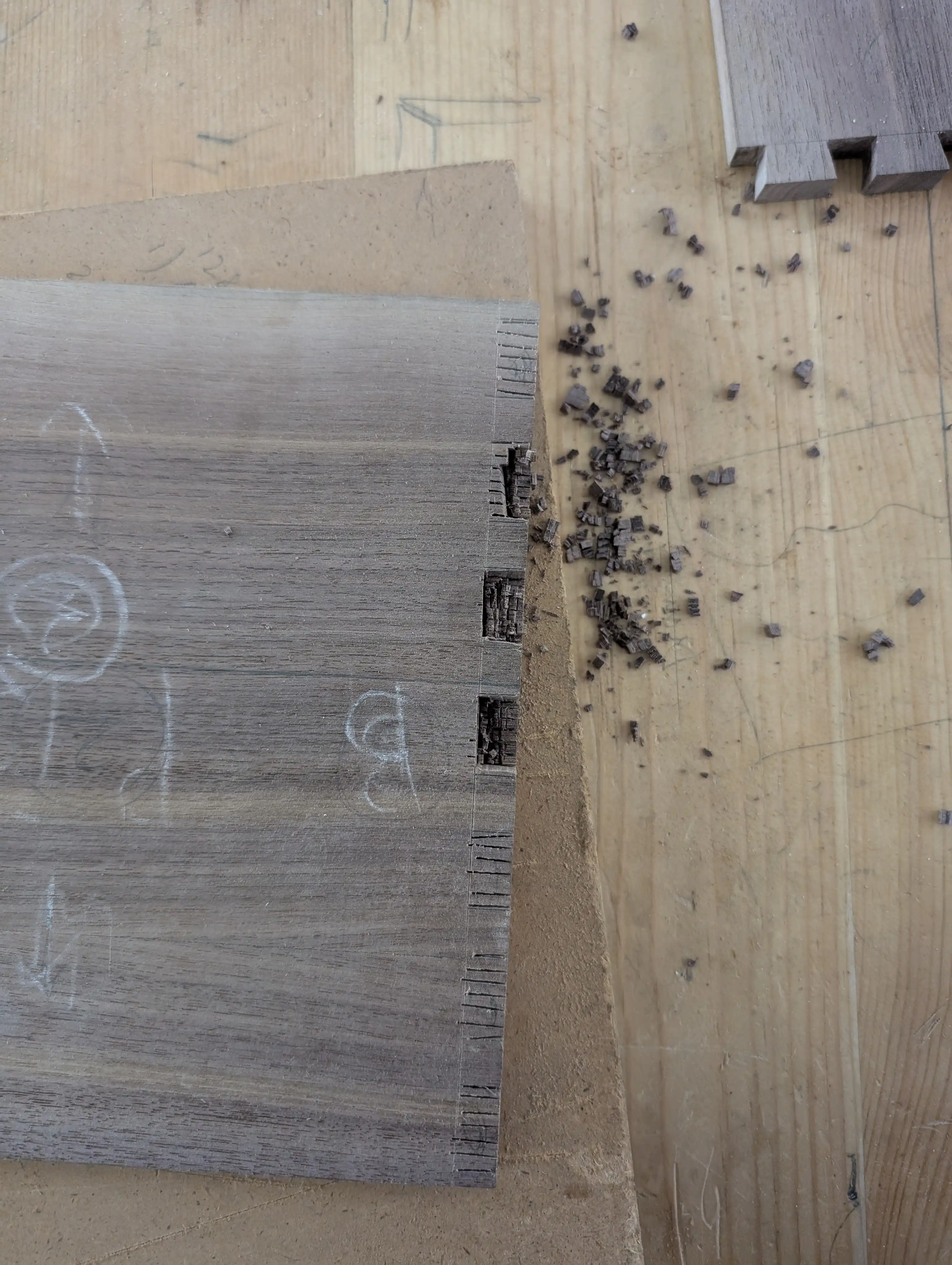 Partially cut pins on a woarkbench.