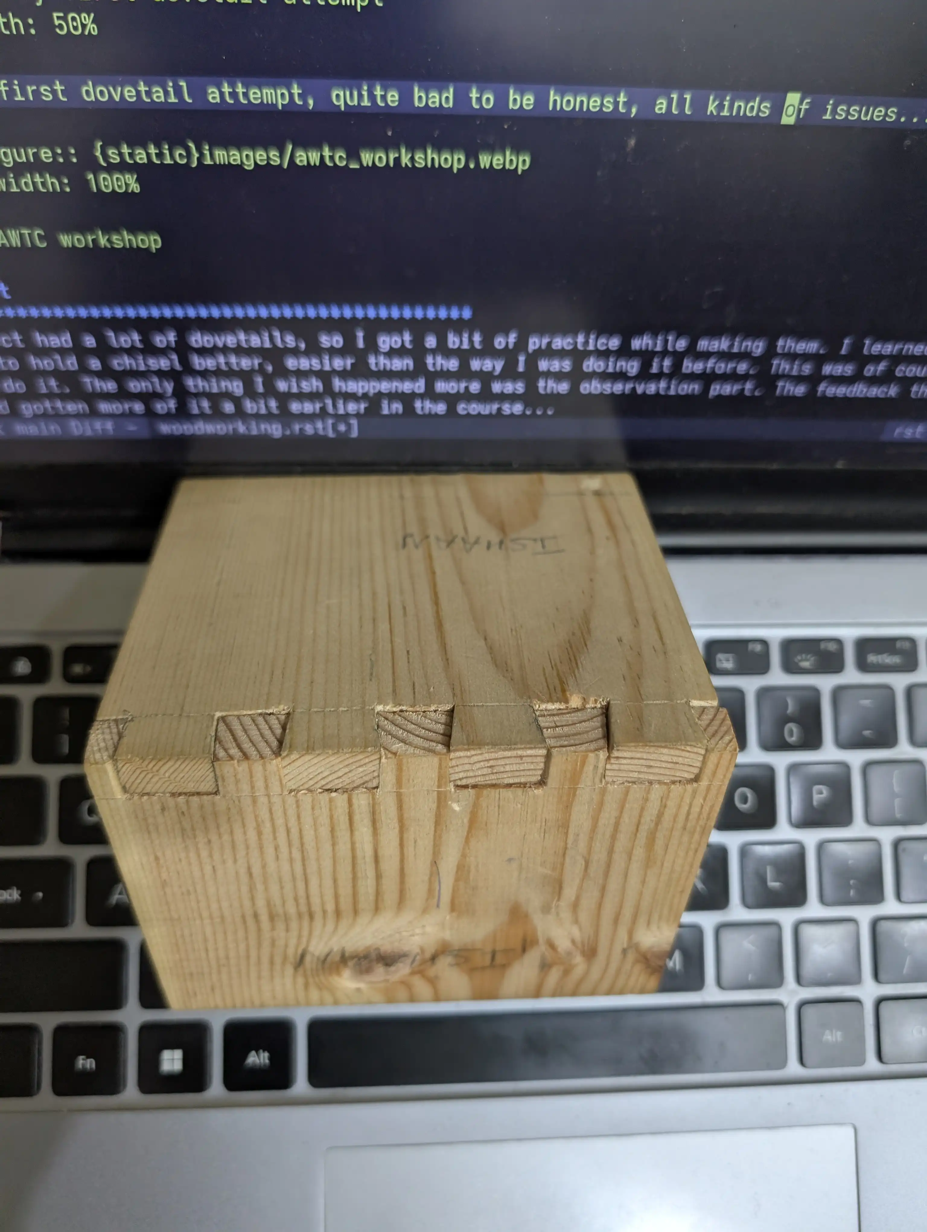 A dovetail joint sitting on a laptop