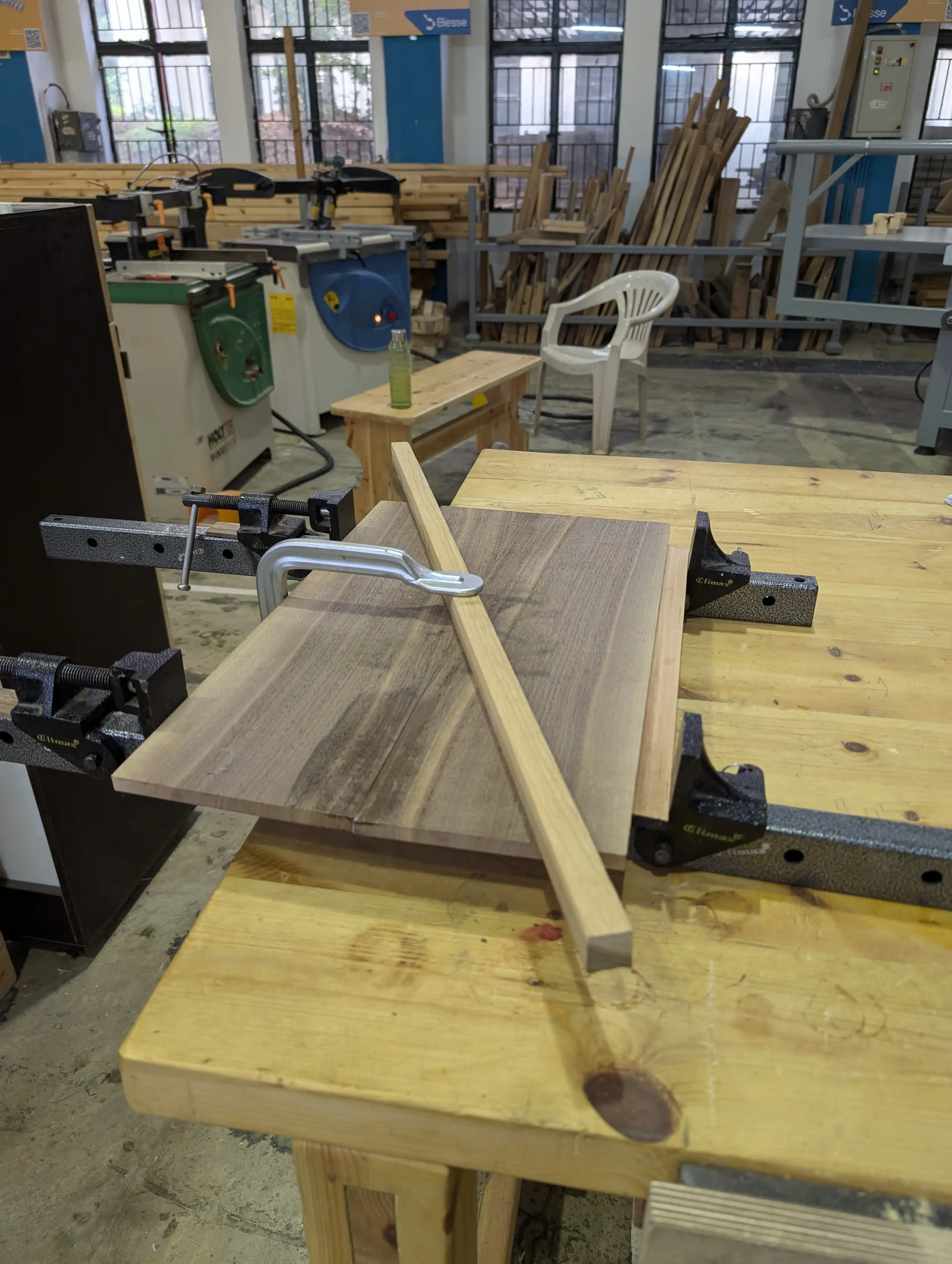 Glued walnut pieces held by clamps.